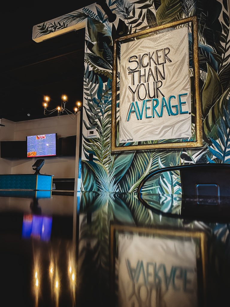 Rotating gallery wall at Chillax Tap & Co. featuring colorful artwork by local St. Louis artists."